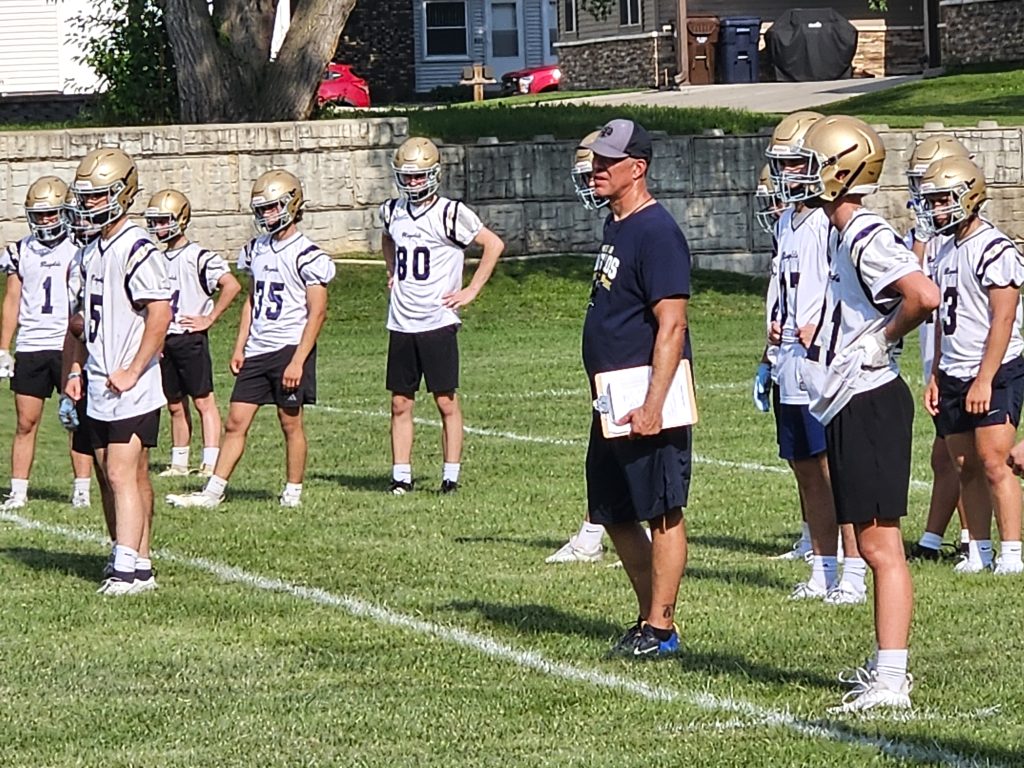 Aquinas football coach Tom Lee and his players listen for instruction before the next snap of a joint practice with Onalaska on Monday. -- TODD SOMMERFELDT PHOTO