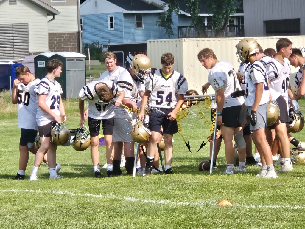 Aquinas football players get a drink between drills during a joint practice with Onalaska on Monday. -- TODD SOMMERFELDT PHOTO