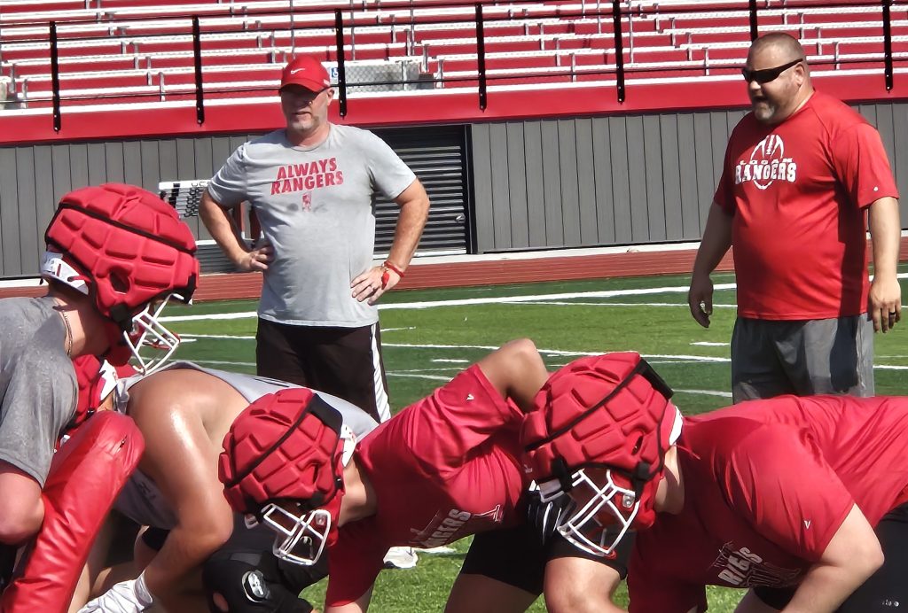Logan football coaches Casey Knoble and Brock Harney watch players execute a play at Tuesday morning's practice at Swanson Field. -- TODD SOMMERFELDT PHOTO