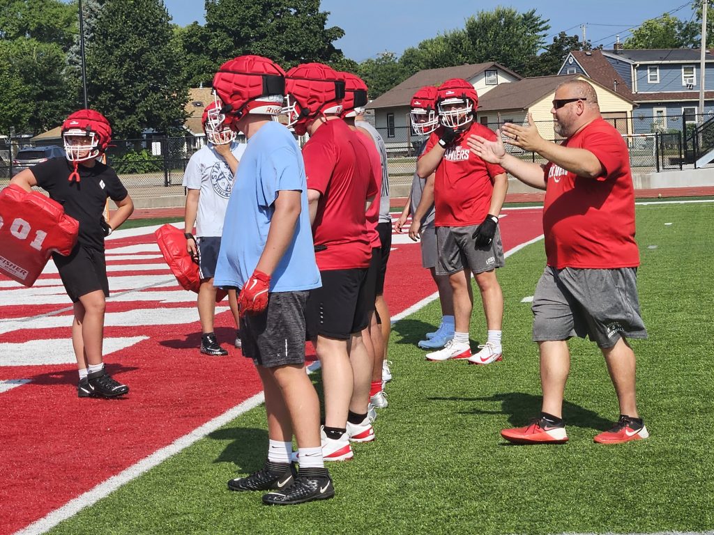 Logan assistant coach Brock Harney guides his players through a drill during Tuesday morning's practice at Swanson Field. -- TODD SOMMERFELDT PHOTO