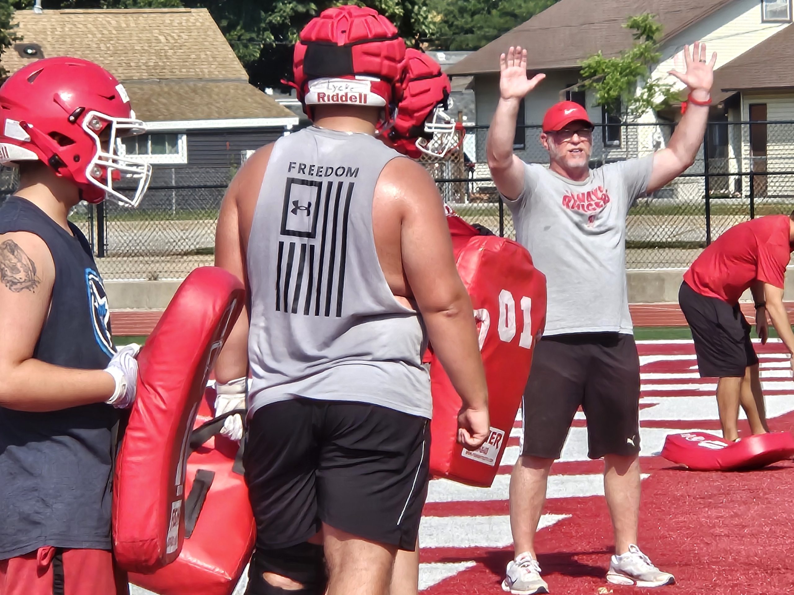 Logan football coach Casey Knoble gestures to his players as they work on a drill during Tuesday morning's practice at Swanson Field. -- TODD SOMMERFELDT PHOTO
