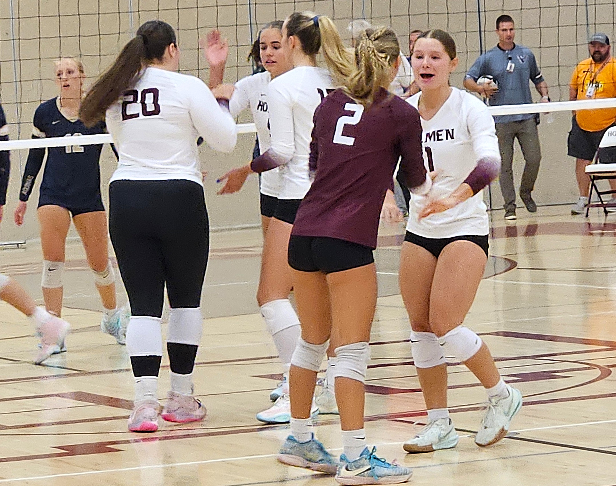 Holmen senior Makenna McHugh slaps hands with teammate Macy Kline as Holmen celebrates a point during Tuesday's MVC match against Aquinas. -- TODD SOMMERFELDT PHOTO