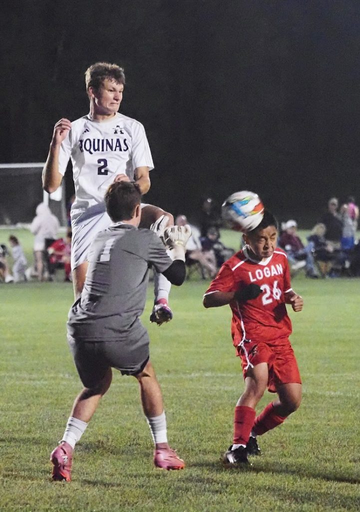 Logan junior Sengpao Xiong attempts a header on goal, but he was stopped by Aquinas goalkeeper Cameron Reinhart and Tegan Schott. -- TARA WALTERS PHOTO