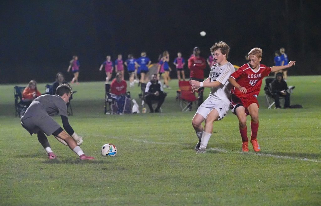 Aquinas goalkeeper Cameron Reinhart stops an attempt to tie the score by Logan freshman Kai Holzer a freshman. -- TARA WALTERS PHOTO