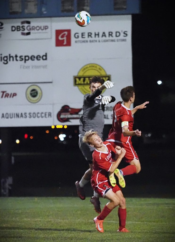 Aquinas goalkeeper Cameron Reinhart blocks a shot attempt by Logan's Kai Holzer and Brecken Jackson in the last few minutes of the game at Fields for Kids. Aquinas won 2-1. -- TARA WALTERS PHOTO