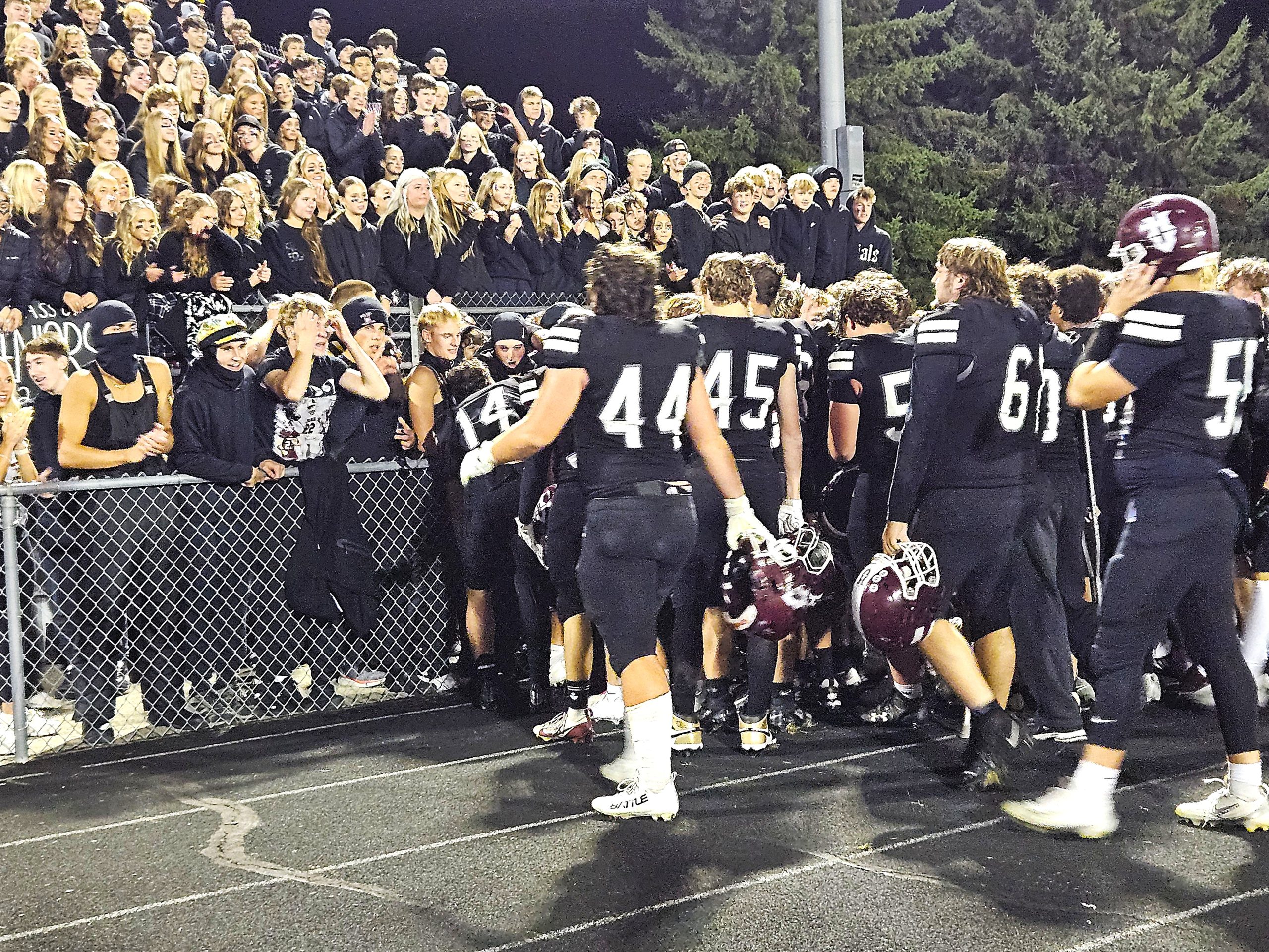 The Holmen High School football team celebrates with its student section after beating Onalaska 19-15 on Friday. -- TODD SOMMERFELDT PHOTO