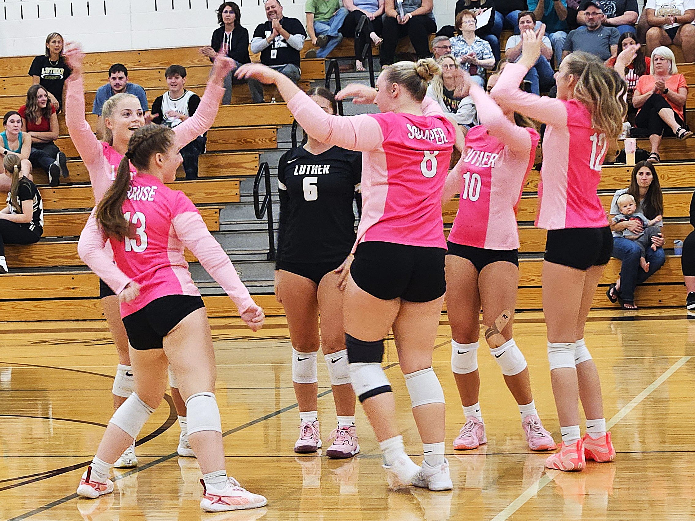 The Onalaska Luther volleyball team celebrates a point during a Coulee Conference match against Arcadia. -- TODD SOMMERFELDT PHOTO