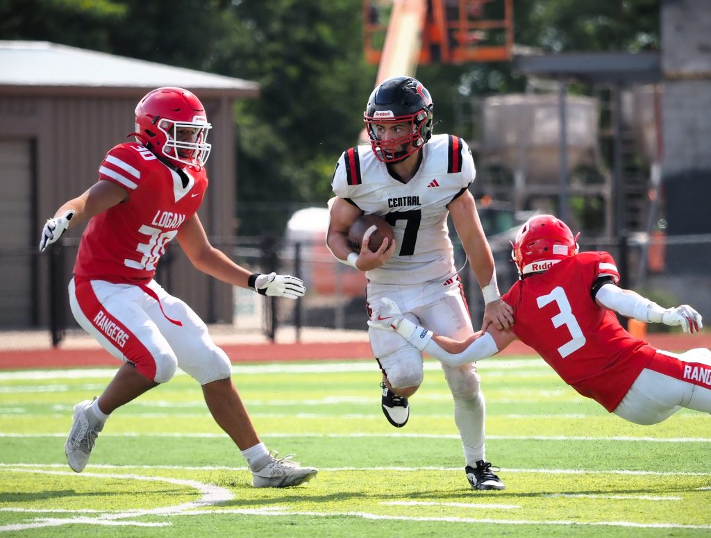 Central senior Christian Rudrud runs between Logan defenders during Saturday's football game at Swanson Field. -- TARA WALTERS PHOTO