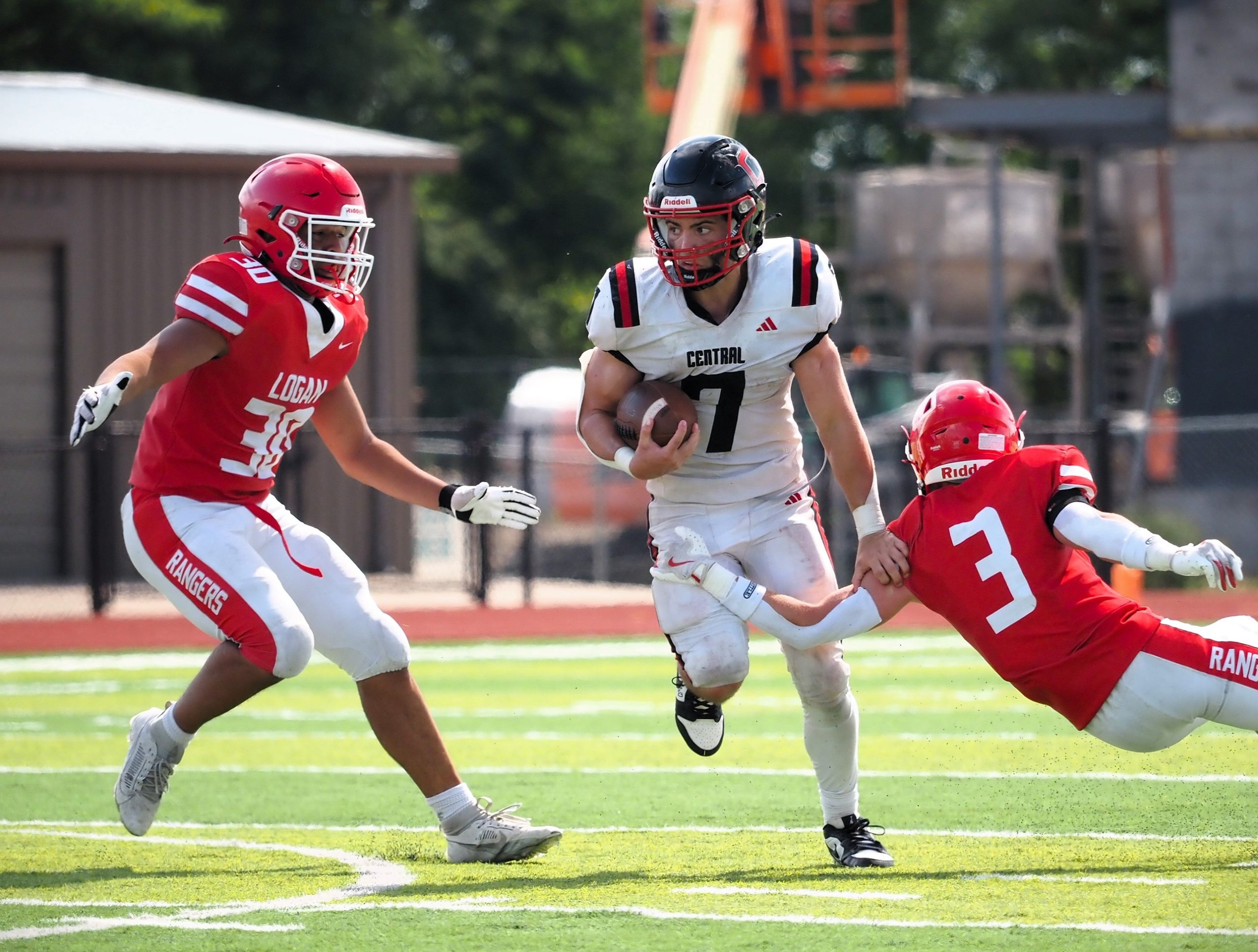 Central senior Christian Rudrud runs between Logan defenders during Saturday's football game at Swanson Field. -- TARA WALTERS PHOTO