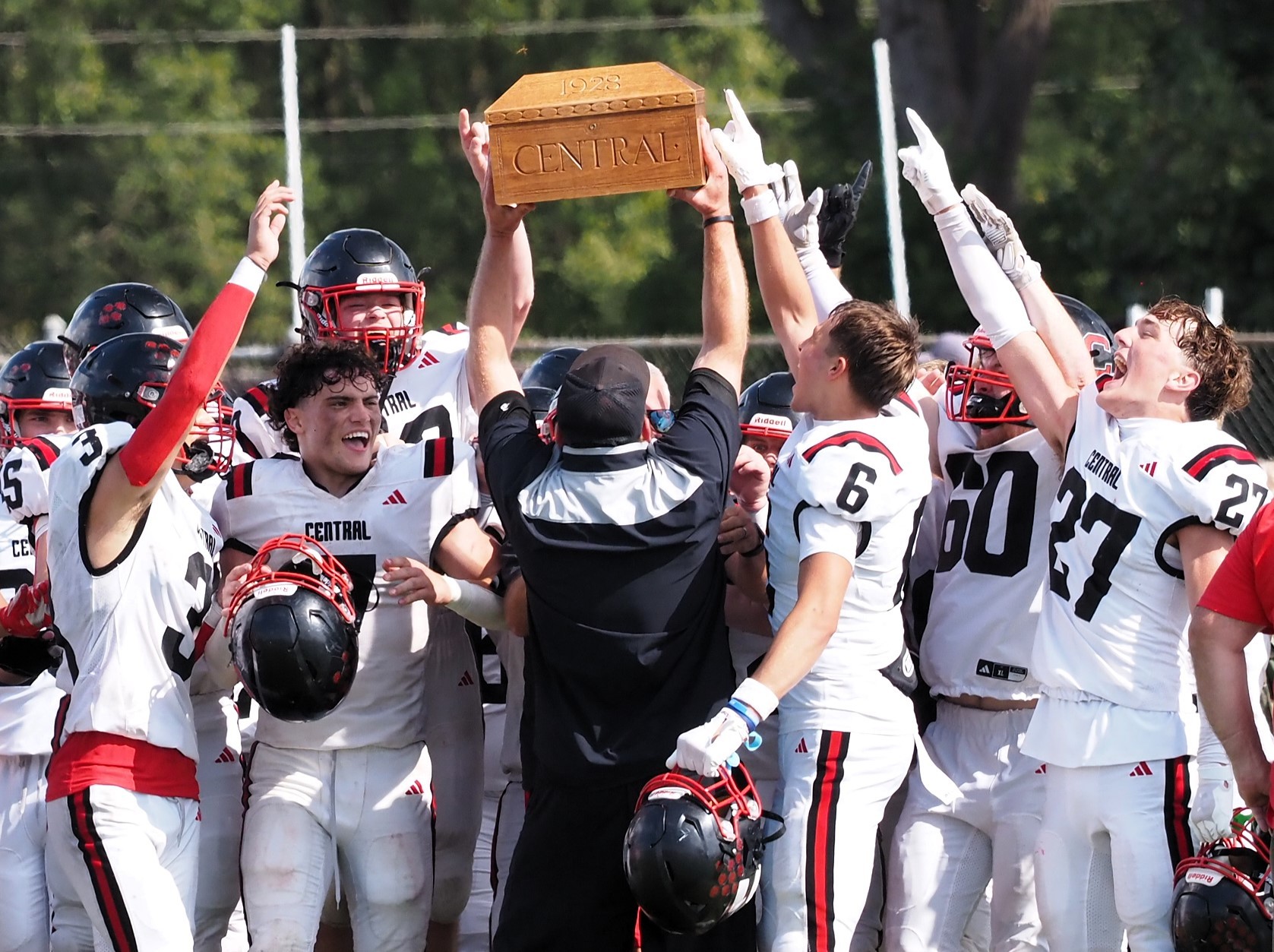 The Central football team celebrates with the Ark of Victory after beating Logan 13-12 Saturday at Swanson Field. -- TARA WALTERS PHOTO