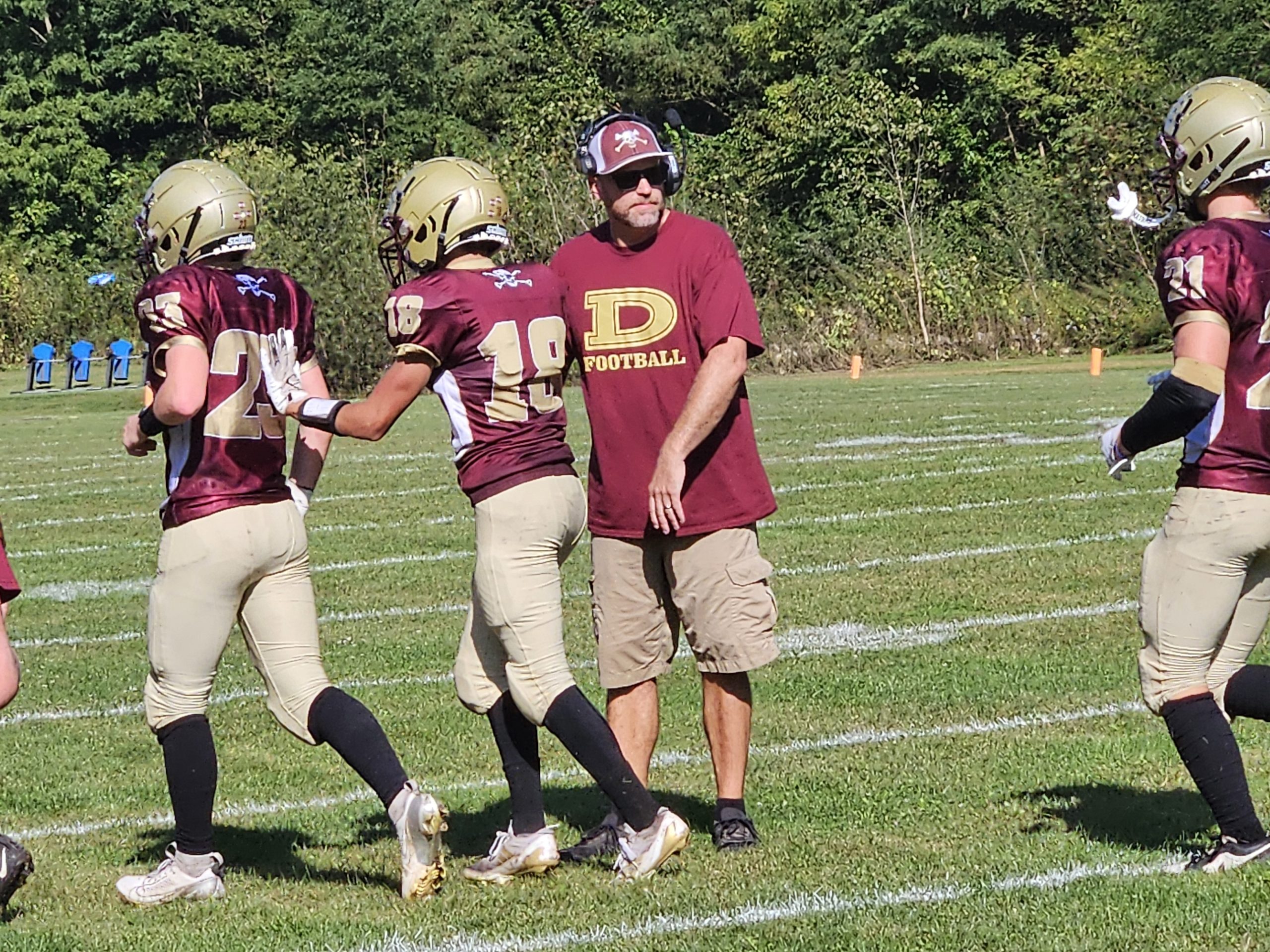 De Soto football coach Ev Wick congratulates his players as they exit the field after a touchdown against Monticello. -- TODD SOMMERFELDT PHOTO