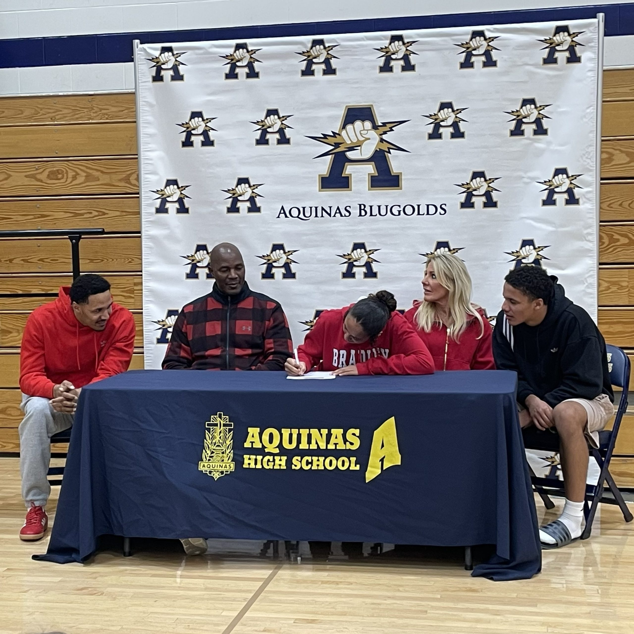 Aquinas senior Sammy Davis signs her Letter of Intent to play basketball for Bradley University on Wednesday. -- SUBMITTED PHOTO