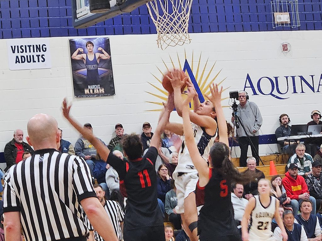 Aquinas senior Sammy Davis goes up for a shot between Central's Alahnna Simpson and Chloe Ackerman during Thursday's 76-38 victory at the Reinhart Athletic Complex. -- TODD SOMMERFELDT PHOTO