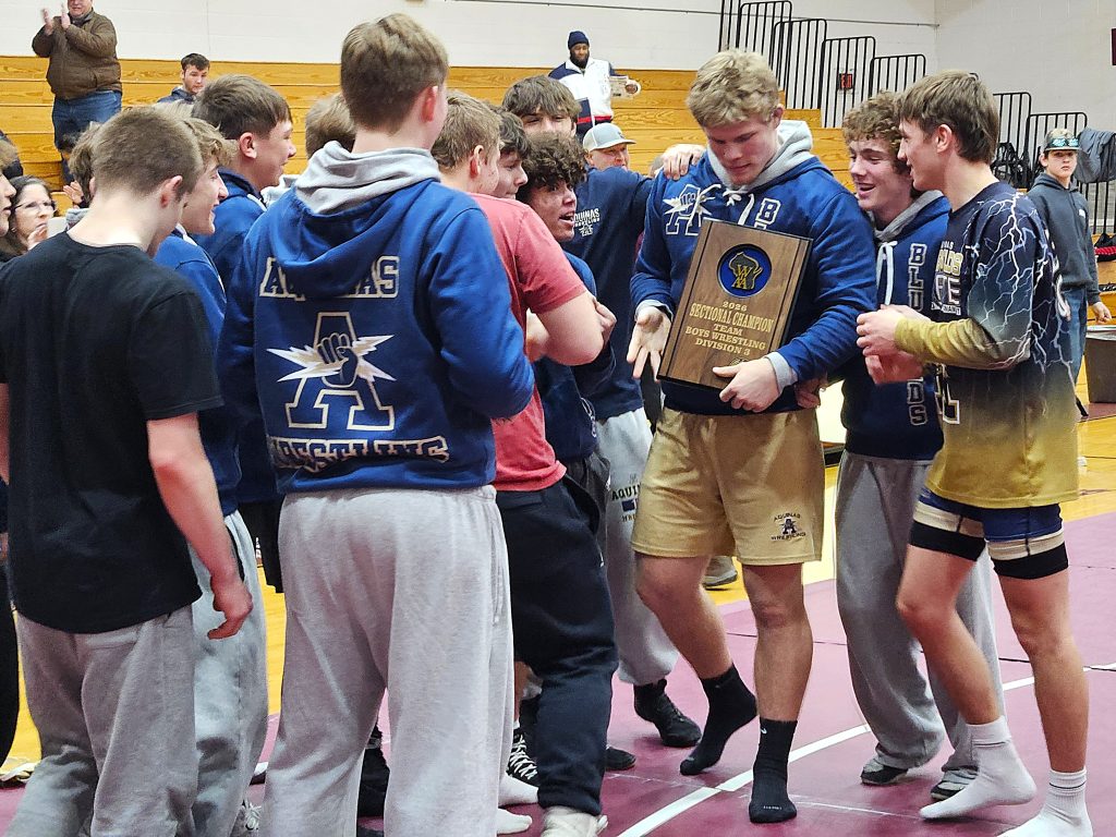 The Aquinas wrestling team celebrates its WIAA Division 3 team sectional championship. -- TODD SOMMERFELDT PHOTO