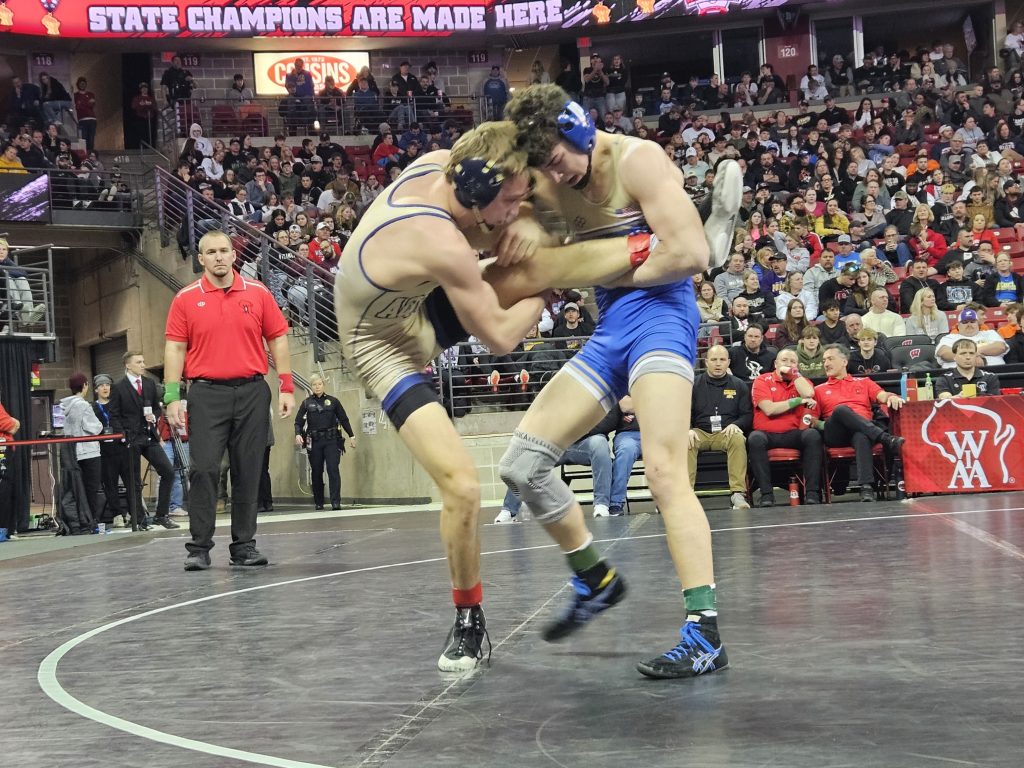 Aquinas senior Roger Flege tries to keep his balance during his Division 3 144-pound championship match at the Kohl Center. -- TODD SOMMERFELDT PHOTO