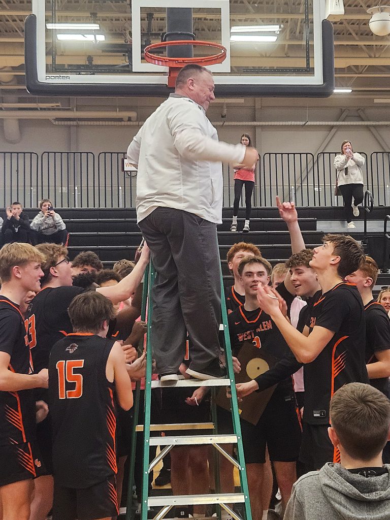 West Salem boys basketball coach Shane Schmeling finishes cutting the net down at Arcadia after the Panthers beat Menomonie to win the WIAA Division 2 sectional championship. -- TODD SOMMERFELDT PHOTO