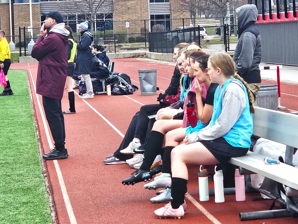 Central girls soccer coach Joe Czerniak and his players watch the RiverHawks compete against Reedsburtg at Swanson Field on Saturday. -- TODD SOMMERFELDT PHOTO