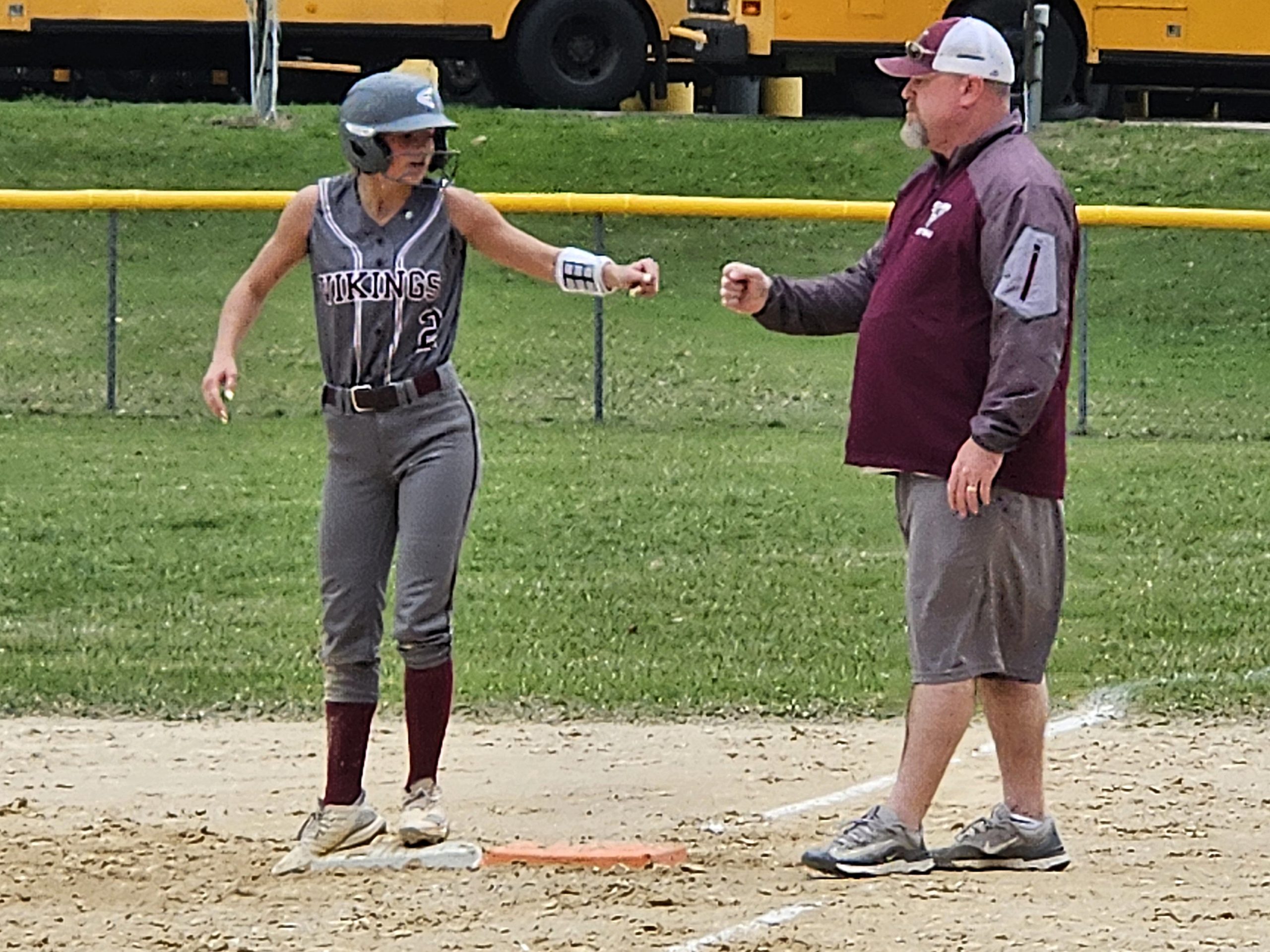 Holmen senior Macy Kline and first-base coach Scott Clifford celebrate a single on Tuesday. -- TODD SOMMERFELDT PHOTO