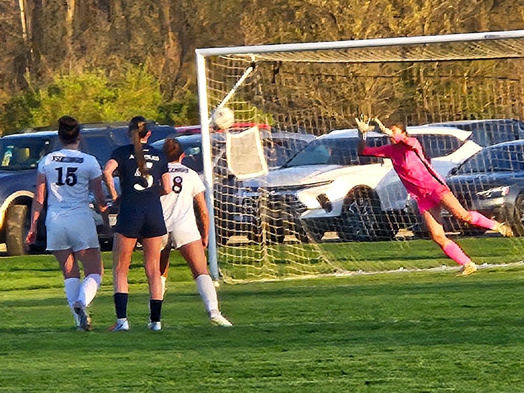 Holmen's Moira Linse dives to stop a penalty kick of Aquinas in her team's 4-0 MVC victory. -- TODD SOMMERFELDT PHOTO