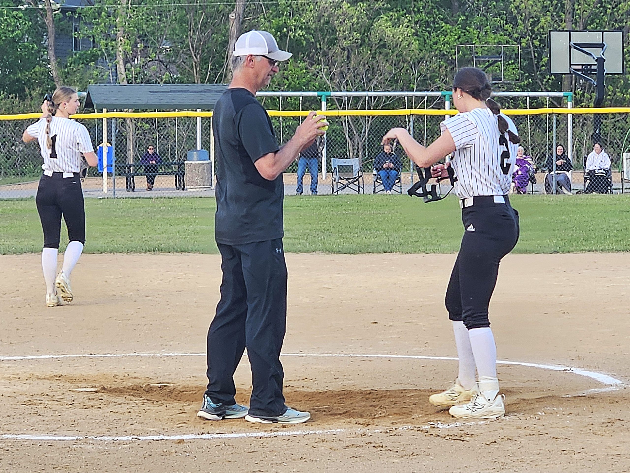 Caledonia softball coach Chad Augedahl talks to Avery Augedahl between innings of a game against La Crescent-Hokah. -- TODD SOMMERFELDT PHOTO