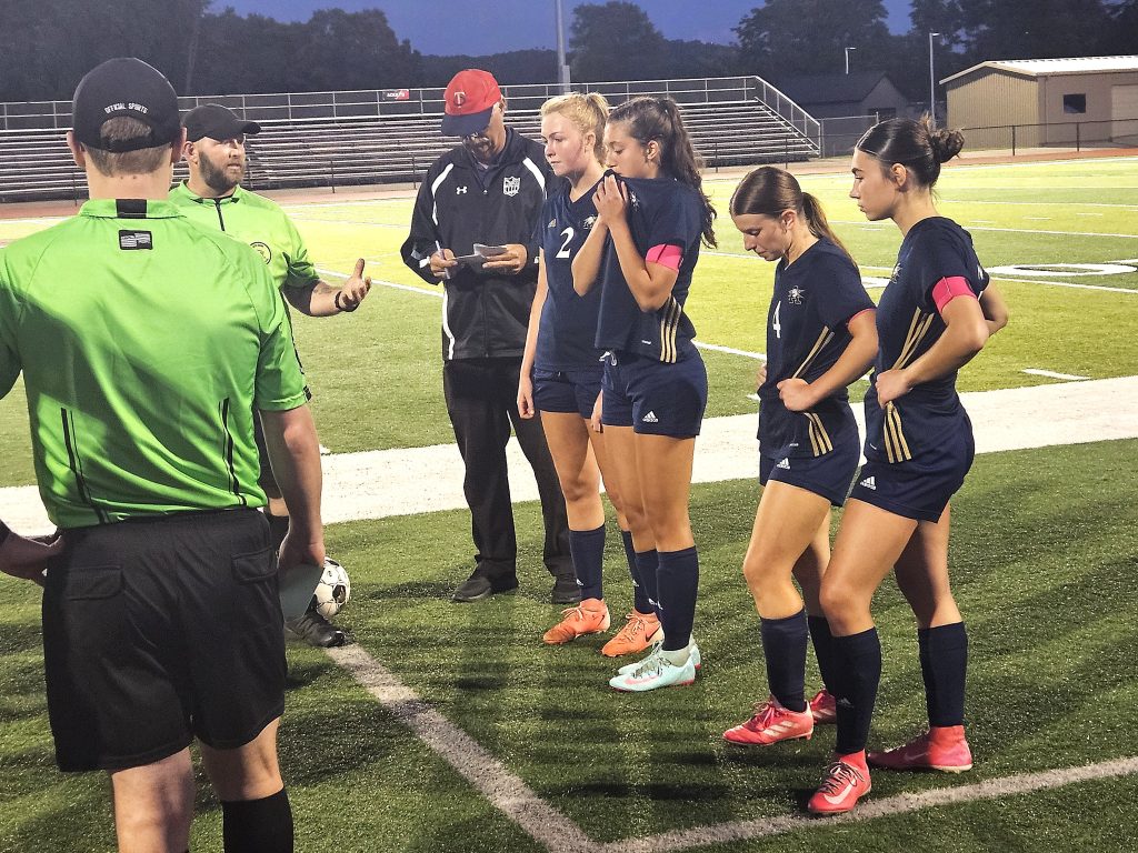 Aquinas girls soccer players and coach Doug Harpenau line up for instructions before penalty kicks against Lodi on Thursday. -- TODD SOMMERFELDT PHOTO
